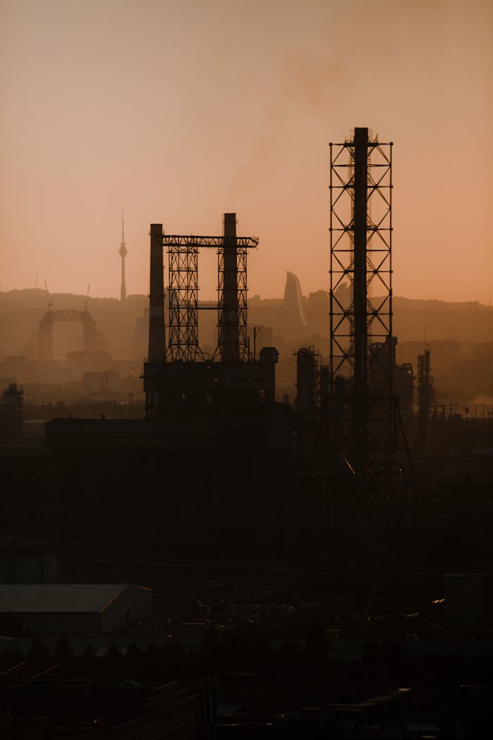 Silhouetted industrial structures against a sunset in Baku, Azerbaijan.